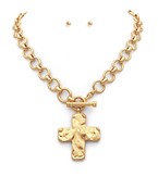 Chunky gold chain necklace with a textured hammered cross pendant and a toggle clasp, a bold and elegant statement piece