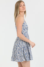  blue floral mini dress with twist-front detail and ruffle hem, styled for a chic and breezy summer look.