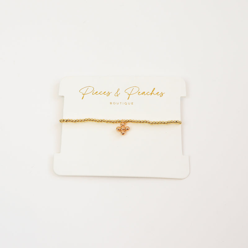 A minimal 4K gold-plated beaded bracelet adorned with a tiny ball bead cross charm for a dreamy, everyday look.
