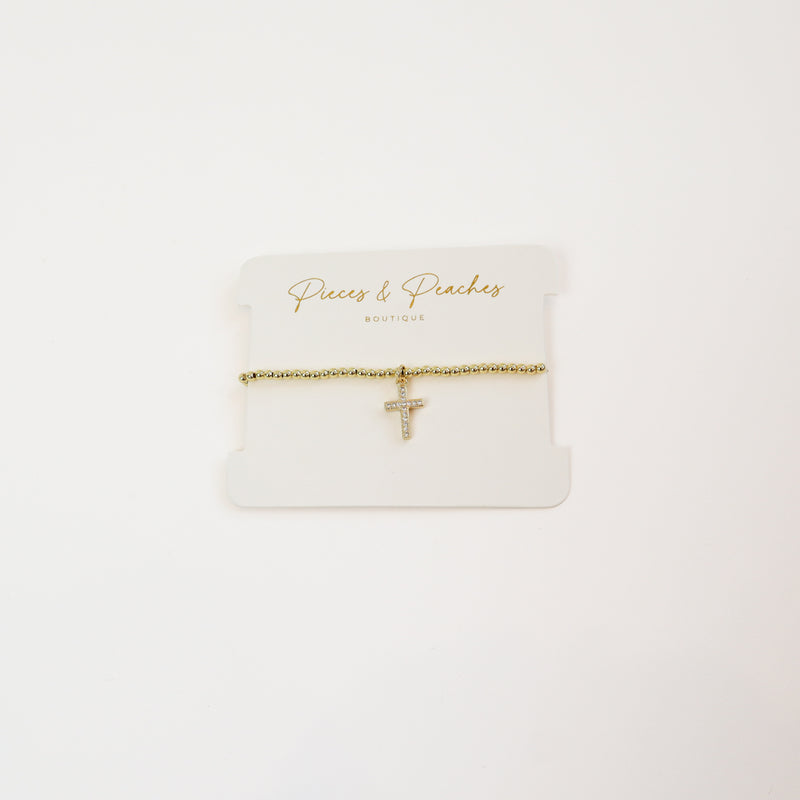 A timeless 14K gold-plated beaded bracelet featuring a minimalist cross charm for a touch of faith and elegance.
