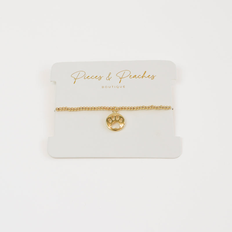 A dainty 14K gold-plated bracelet with 3mm beads and a delicate paw charm, perfect for pet lovers.
