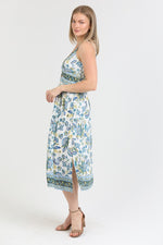 floral midi dress with a twist-front bodice, adjustable straps, and side slit, styled for a summer look.