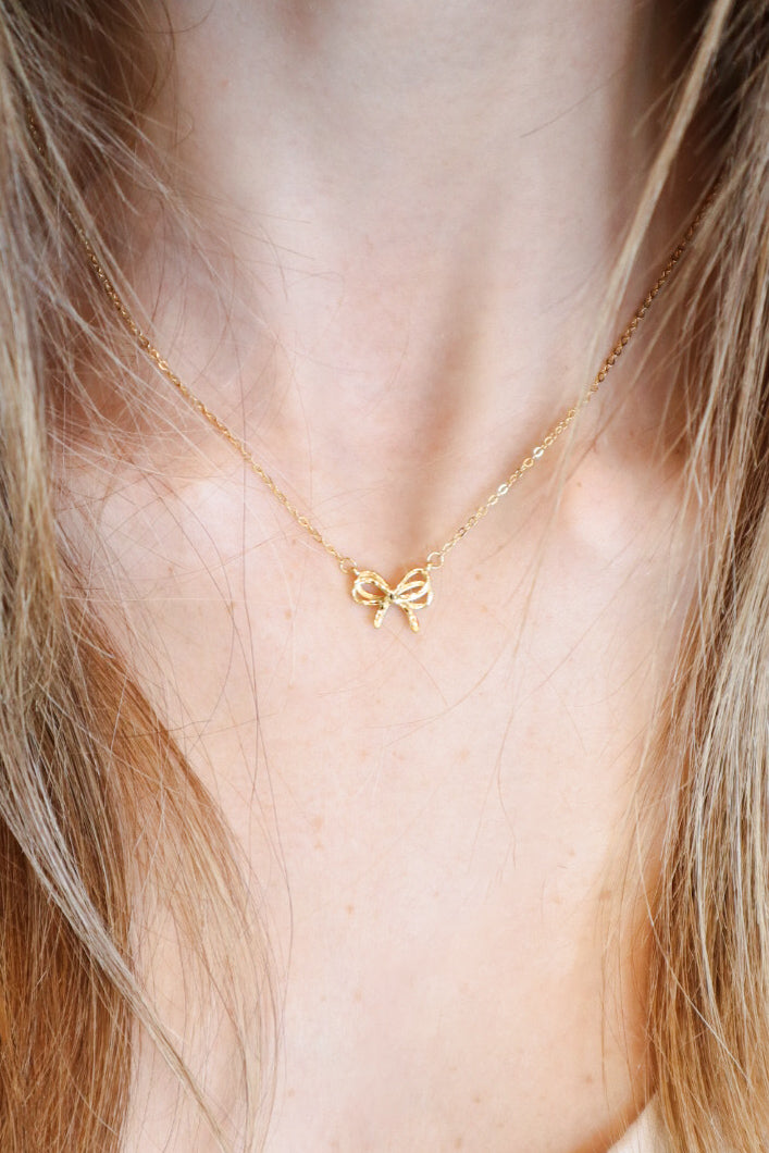 Elegant Dainty Bow Necklace featuring a delicate gold-plated bow pendant on a fine adjustable chain, perfect for minimalistic and sophisticated styling.