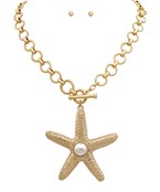 22K gold-plated starfish necklace with pearl accent and matching stud earrings. Coastal-inspired statement jewelry set