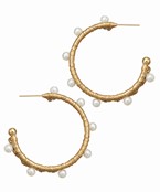 Gold-plated hoop earrings wrapped in raffia with delicate pearl accents, designed for a chic and bohemian-inspired statement look