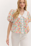 pastel floral puff-sleeve blouse with a delicate eyelet lace collar and button-down front. The top features a soft, textured fabric with a romantic vintage-inspired design.